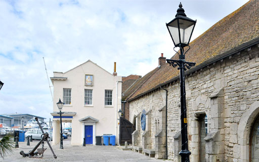 Photo showing an anchor in front of a building