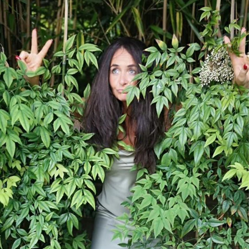 Photo of Luisa Hashtroudi hiding in some trees