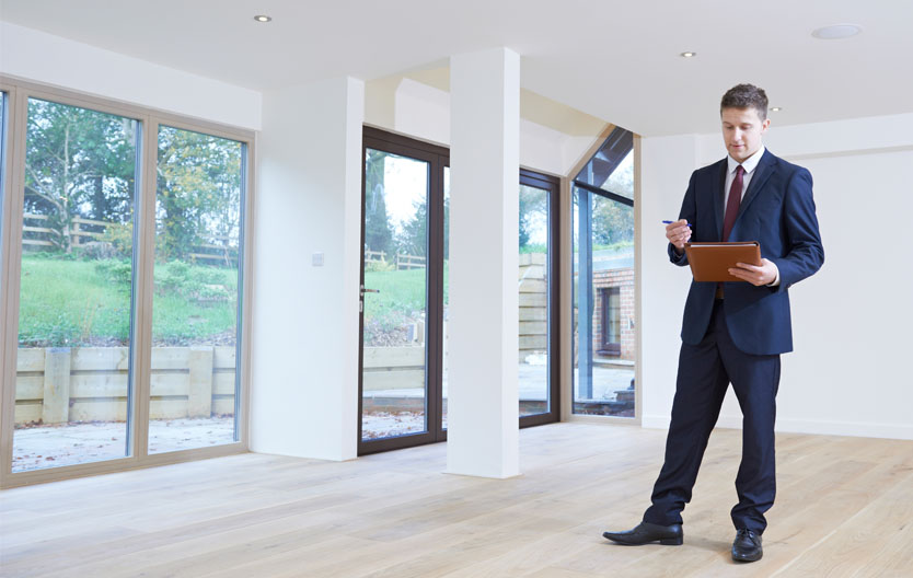 Photo showing an estate agent evaluating an empty house